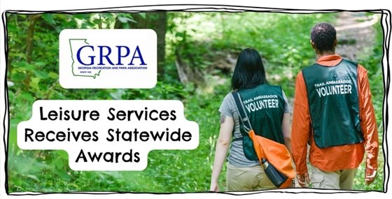 A picture of two Trail Ambassador volunteers walking in the woods