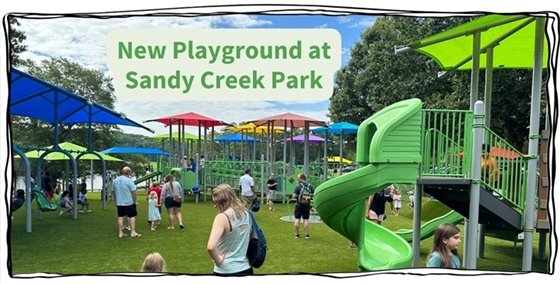 Families standing around the new playground at Sandy Creek Park