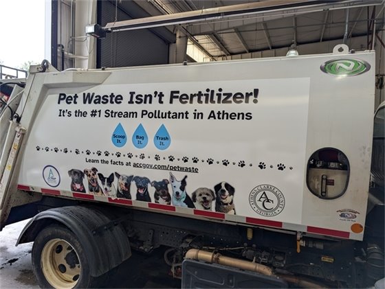 A mini-packer truck with a stormwater-themed wrap.