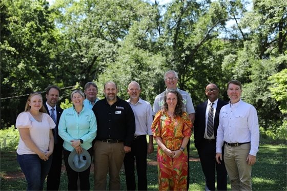 A medium group of ACC employees poses for a picture on a sunny day at the Dudley Park celebration