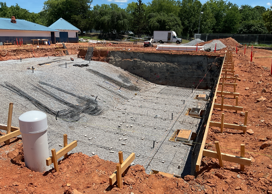 A prepared pit lined with gravel and rebar, and skirted by wooden forms.