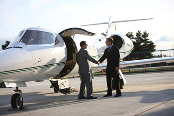 Private Jet from Switzerland, two men in suits shaking hands outside of the plane door.