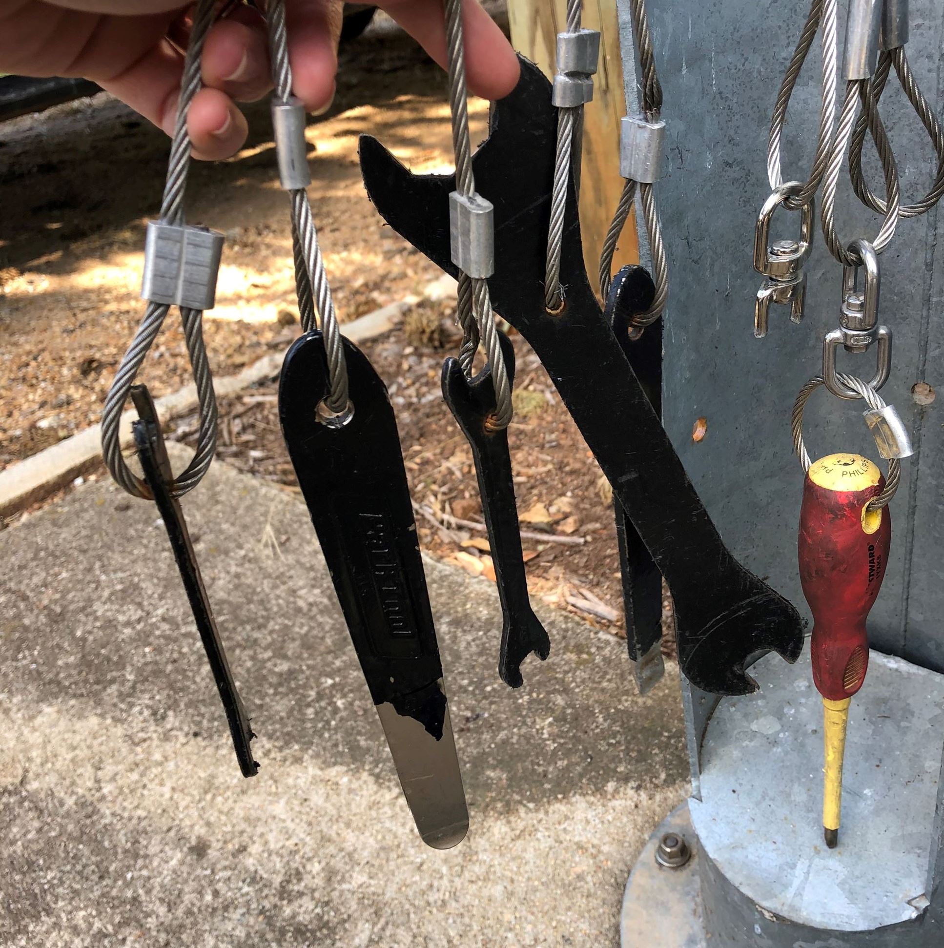 set of tools hanging from the outdoor bike repair station