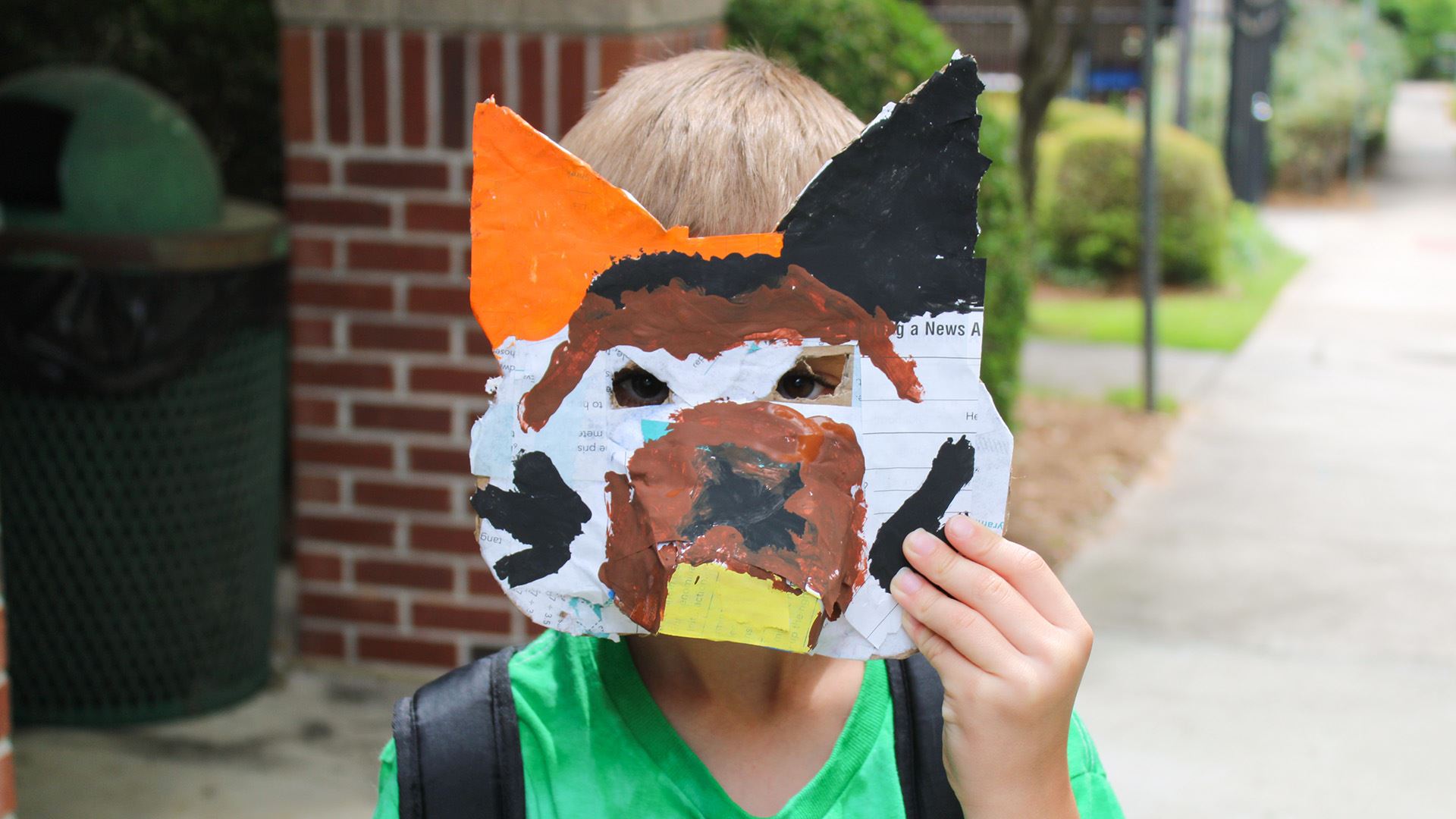 A child wearing a papier-mache dog mask they made at Rocksprings' summer camp.