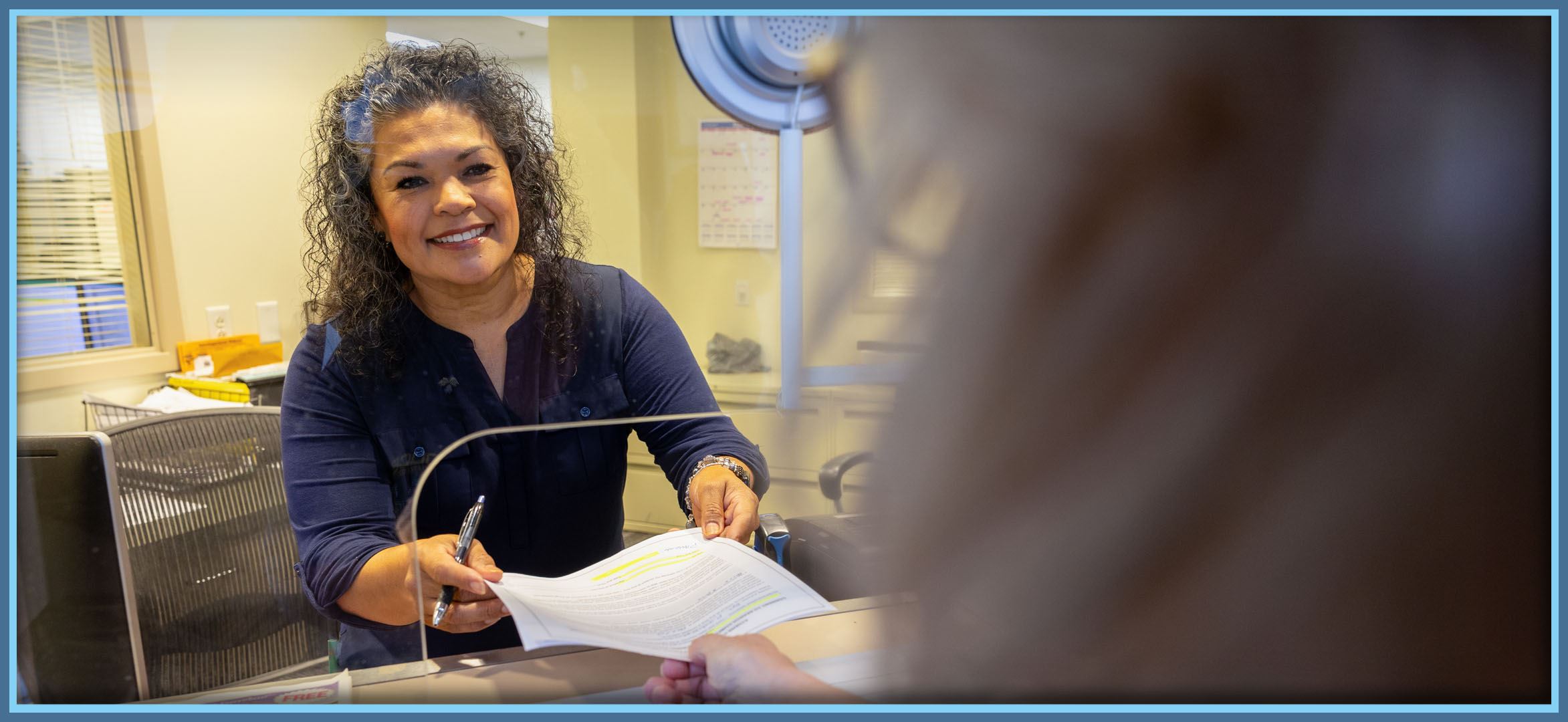 Record clerk hands document to customer