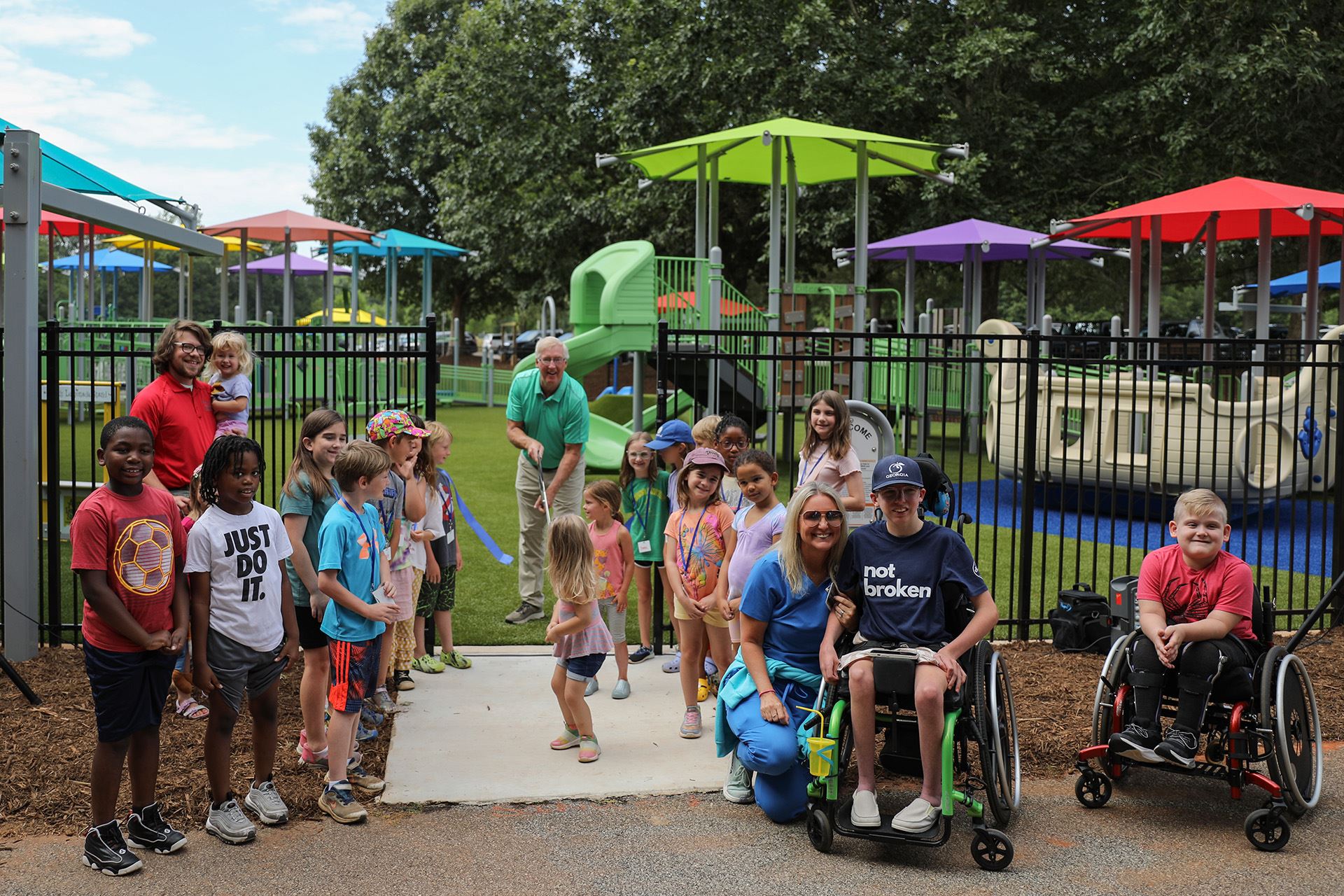 A groupd of children pose as the ribbon across the playground's entrance is cut.