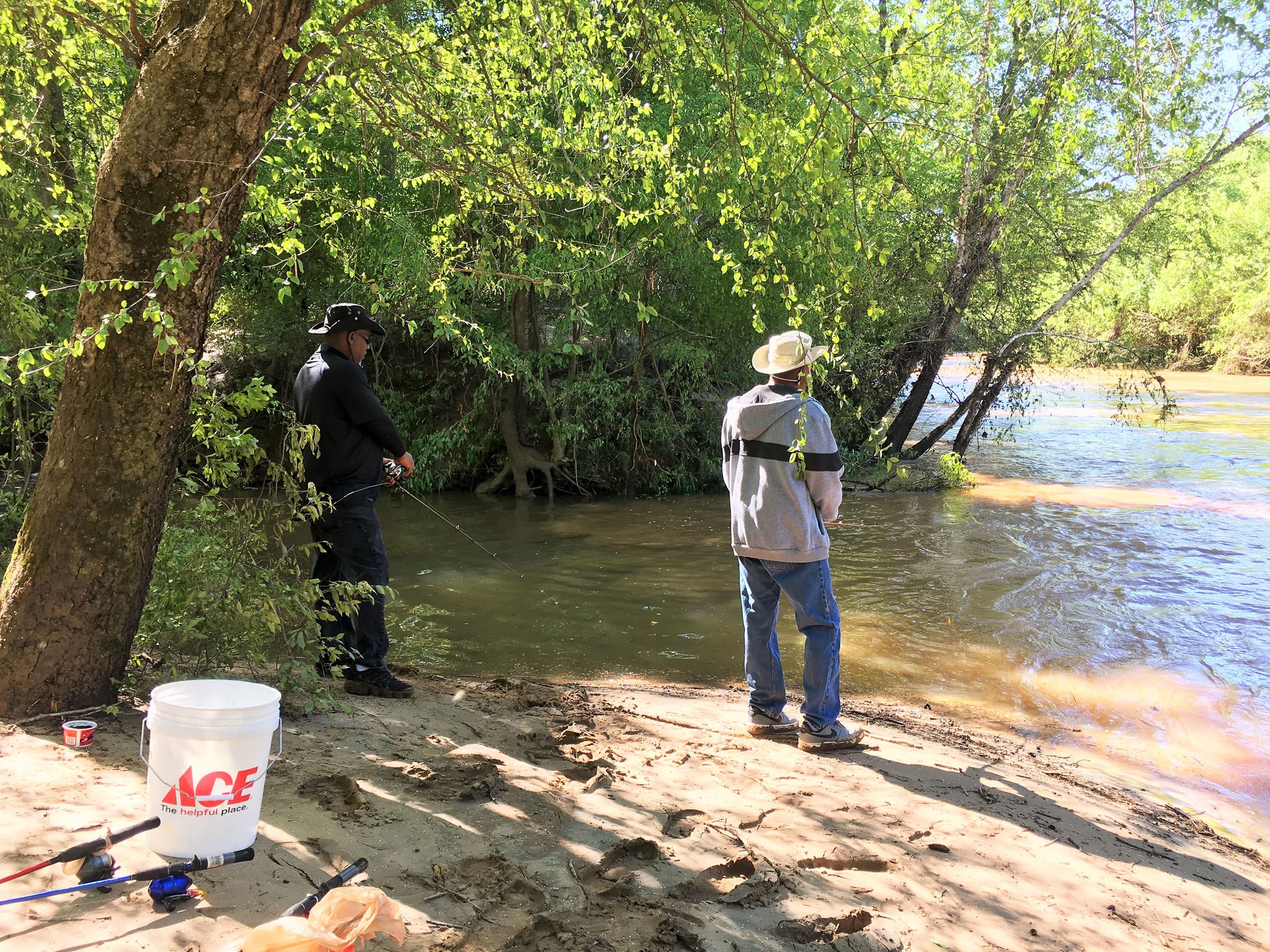 Two men fishing on the riverbank