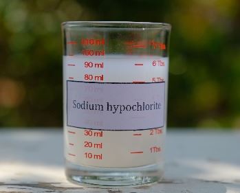 A beaker of Sodium Hypochlorite with a label stating the same
