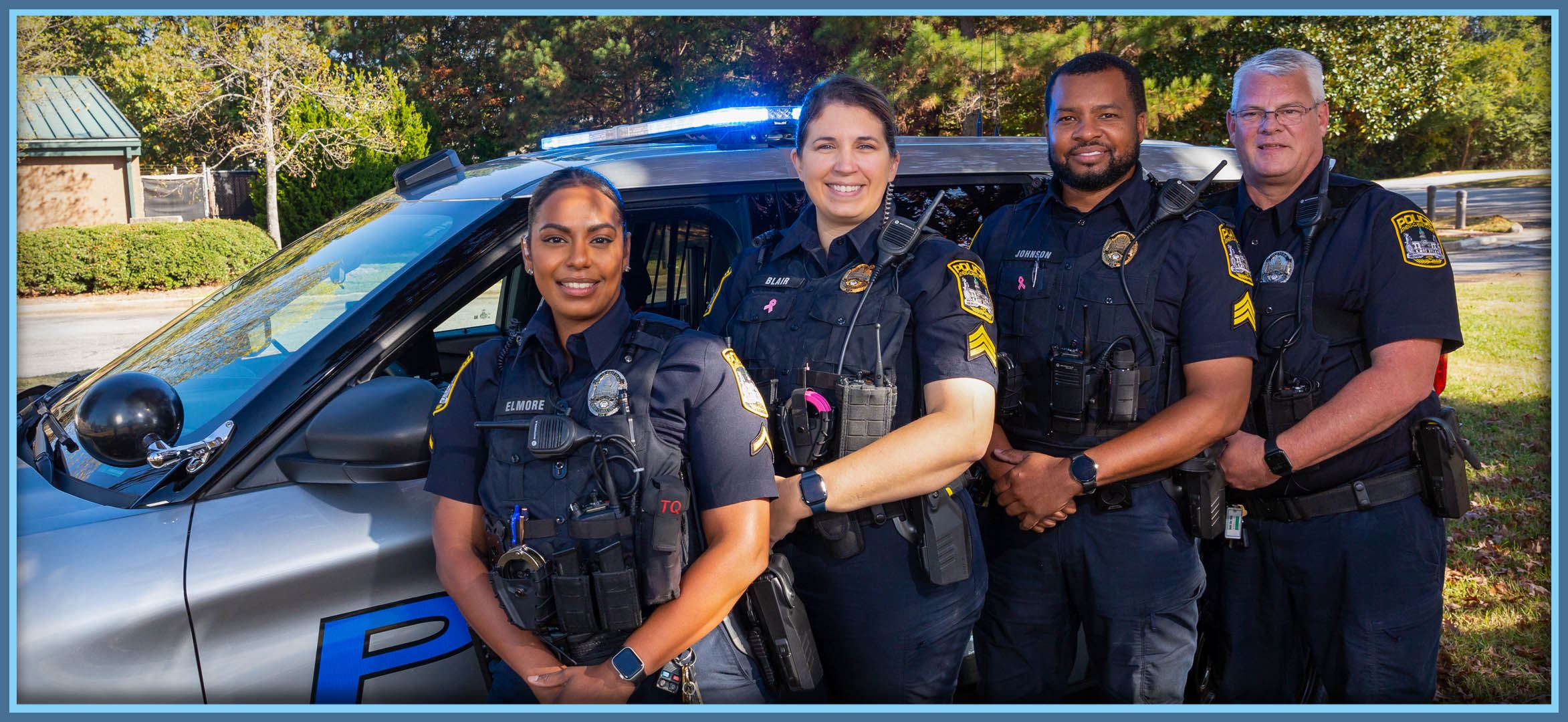 Officers standing next to police vehicle