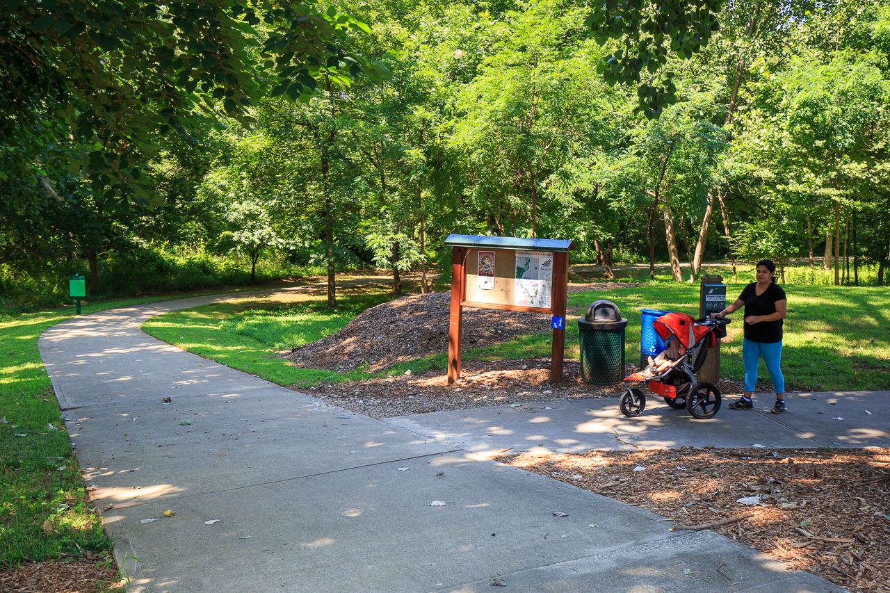 Woman walking with stroller on paved trail